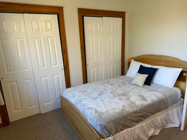 a bed sitting in a bedroom next to a bathroom