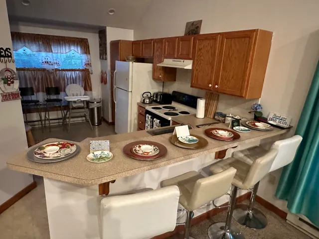 a kitchen with a refrigerator and a stove top oven