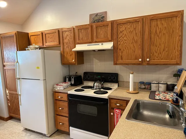 a kitchen with stainless steel appliances a refrigerator a stove a sink and cabinets
