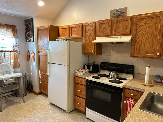 a kitchen with stainless steel appliances granite countertop a refrigerator stove and sink