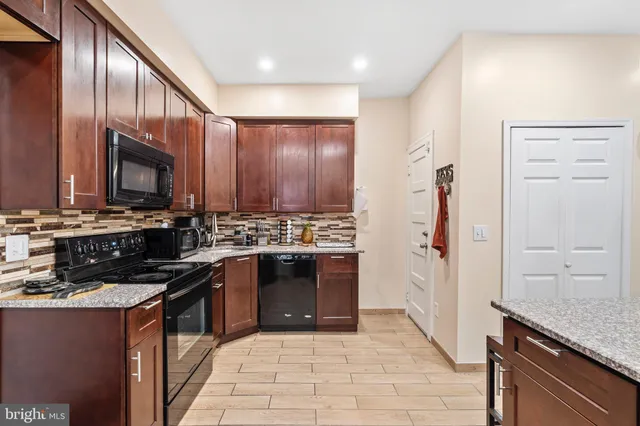 a kitchen with stainless steel appliances granite countertop a stove a sink and a refrigerator