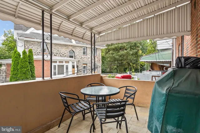 a outdoor dining space with a table and chairs