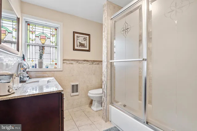 a bathroom with a granite countertop sink toilet and shower