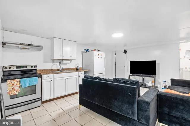 a living room with stainless steel appliances kitchen island granite countertop a sink and cabinets