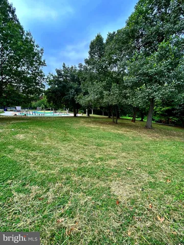 a view of a green field with trees in the background