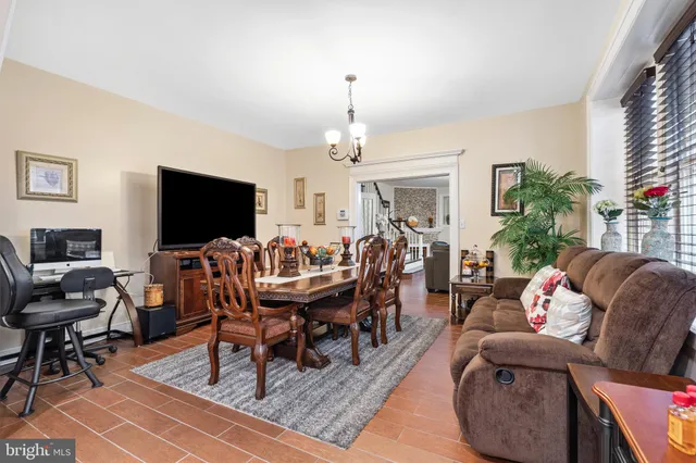 a living room with furniture a flat screen tv and a chandelier