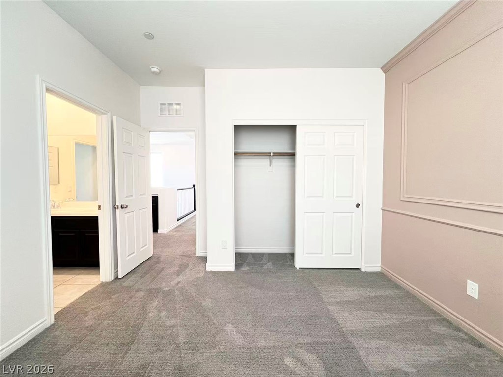 925 Bayberry Ridge Street Henderson, NV 89052 - Photo 24 of 27 A well-appointed bedroom awaits, offering plush carpeting and a convenient closet for optimal organization.