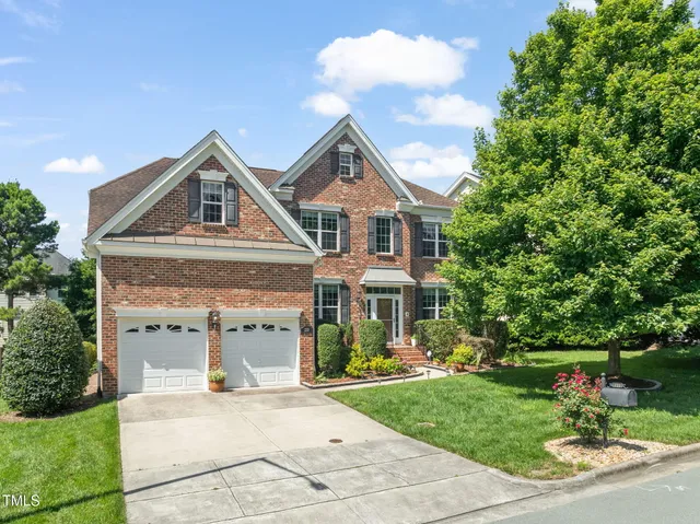 a front view of a house with a yard and potted plants