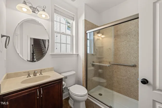 a bathroom with a sink toilet mirror and shower