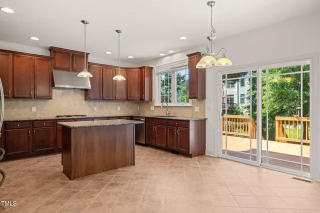 a large kitchen with kitchen island a large island in the center and stainless steel appliances