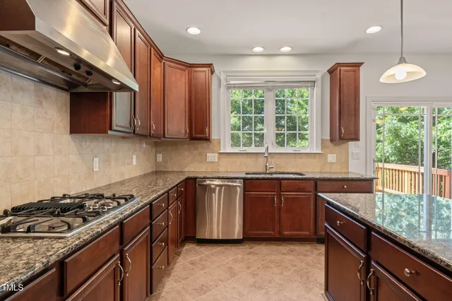 a kitchen with stainless steel appliances granite countertop a stove and a sink