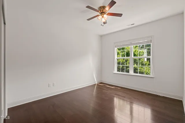 an empty room with a window and wooden floor