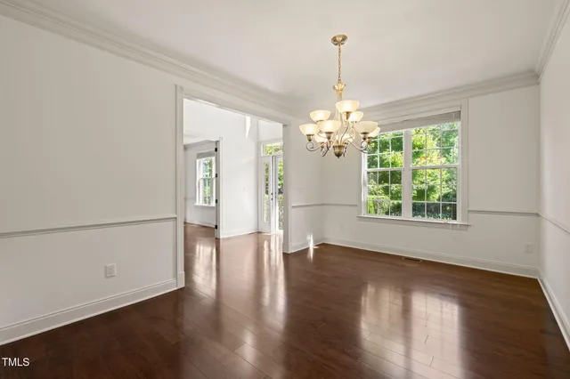 a view of a room with wooden floor chandelier and a window