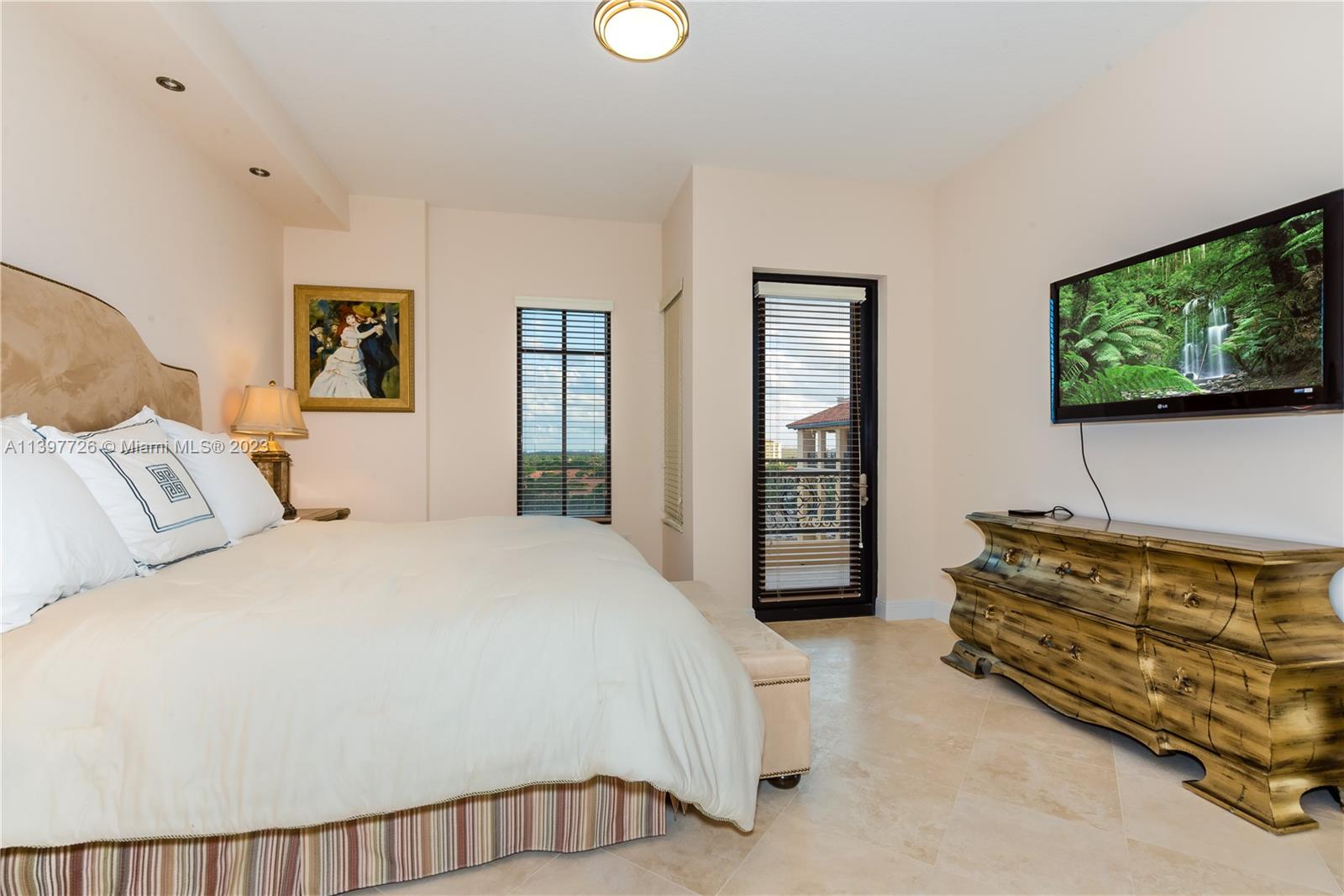 200 East Palmetto Park Road, Unit 700 Boca Raton, FL 33432 - Photo 25 of 31 a spacious bedroom with a bed and a flat screen television