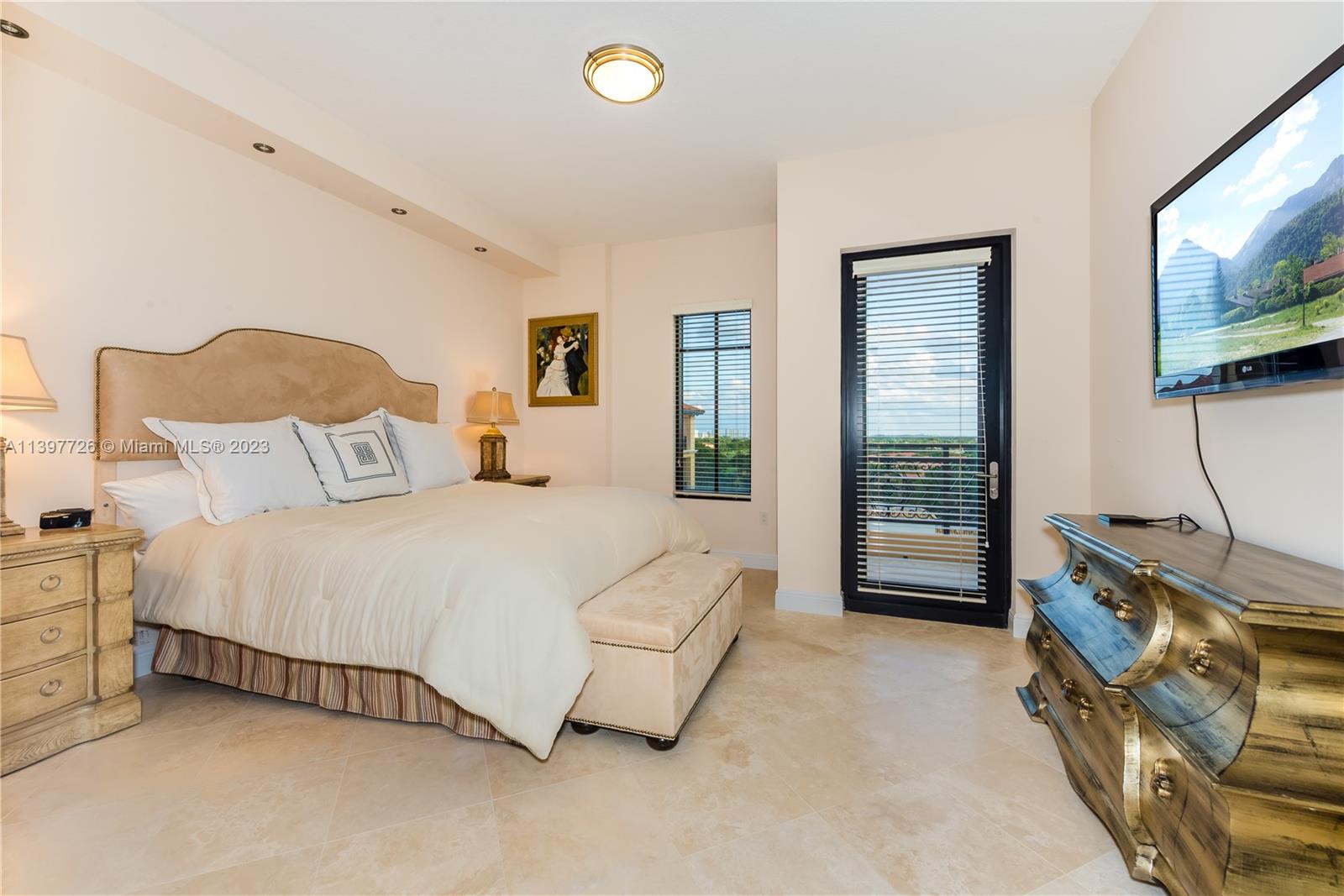 200 East Palmetto Park Road, Unit 700 Boca Raton, FL 33432 - Photo 26 of 31 a bedroom with a bed flat screen tv and a large window