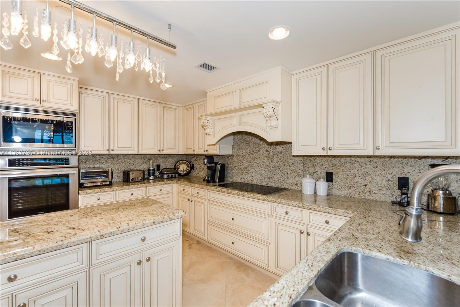 200 East Palmetto Park Road, Unit 700 Boca Raton, FL 33432 - Photo 9 of 31 a kitchen with granite countertop a sink stainless steel appliances and cabinets