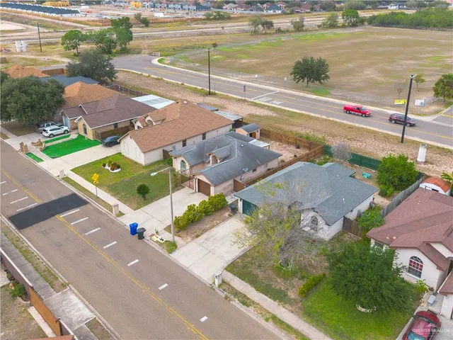 an aerial view of residential houses with outdoor space and parking