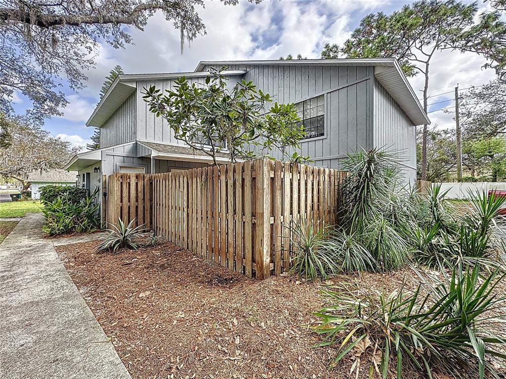 4616 Lighthouse Circle, Unit 101 Orlando, FL 32808 - Photo 1 of 1 a backyard of a house with plants and trees with wooden fence