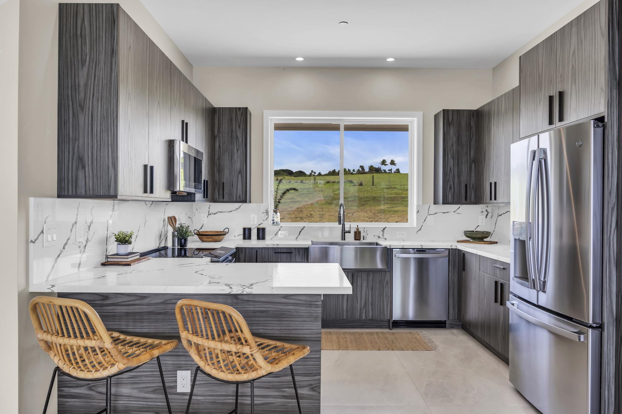 500 Kai Huki Circle, Unit B Haiku, HI 96708 - Photo 6 of 50 a kitchen with stainless steel appliances granite countertop a refrigerator a sink a stove a dining table and chairs