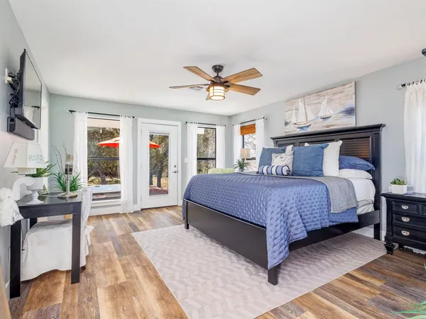 a bedroom with a large bed a flat tv screen and a dresser