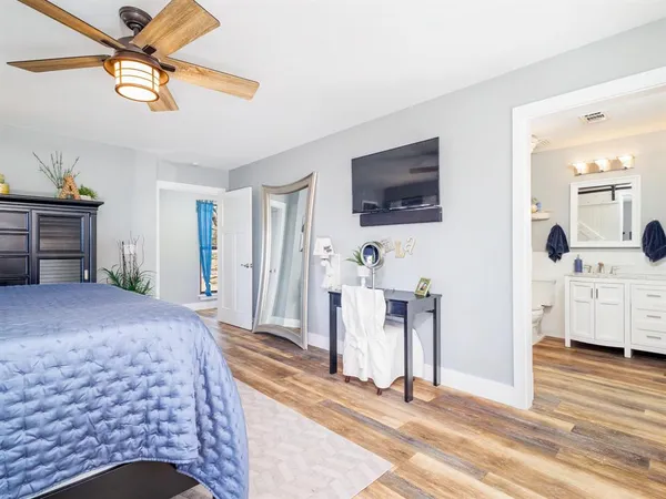 a bedroom with a bed a flat screen tv and dresser