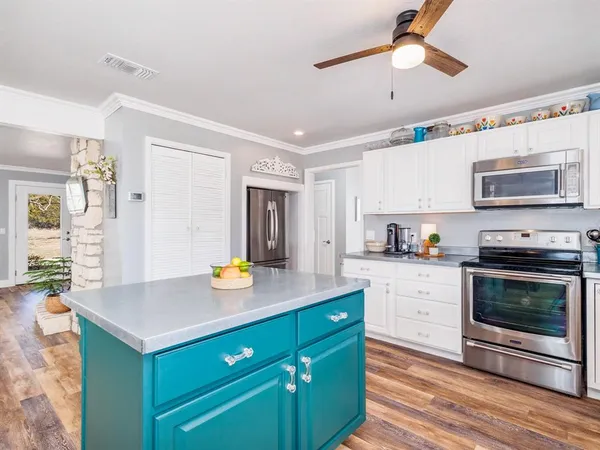 a kitchen with a stove cabinets and window