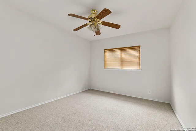 an empty room with a window and a fan