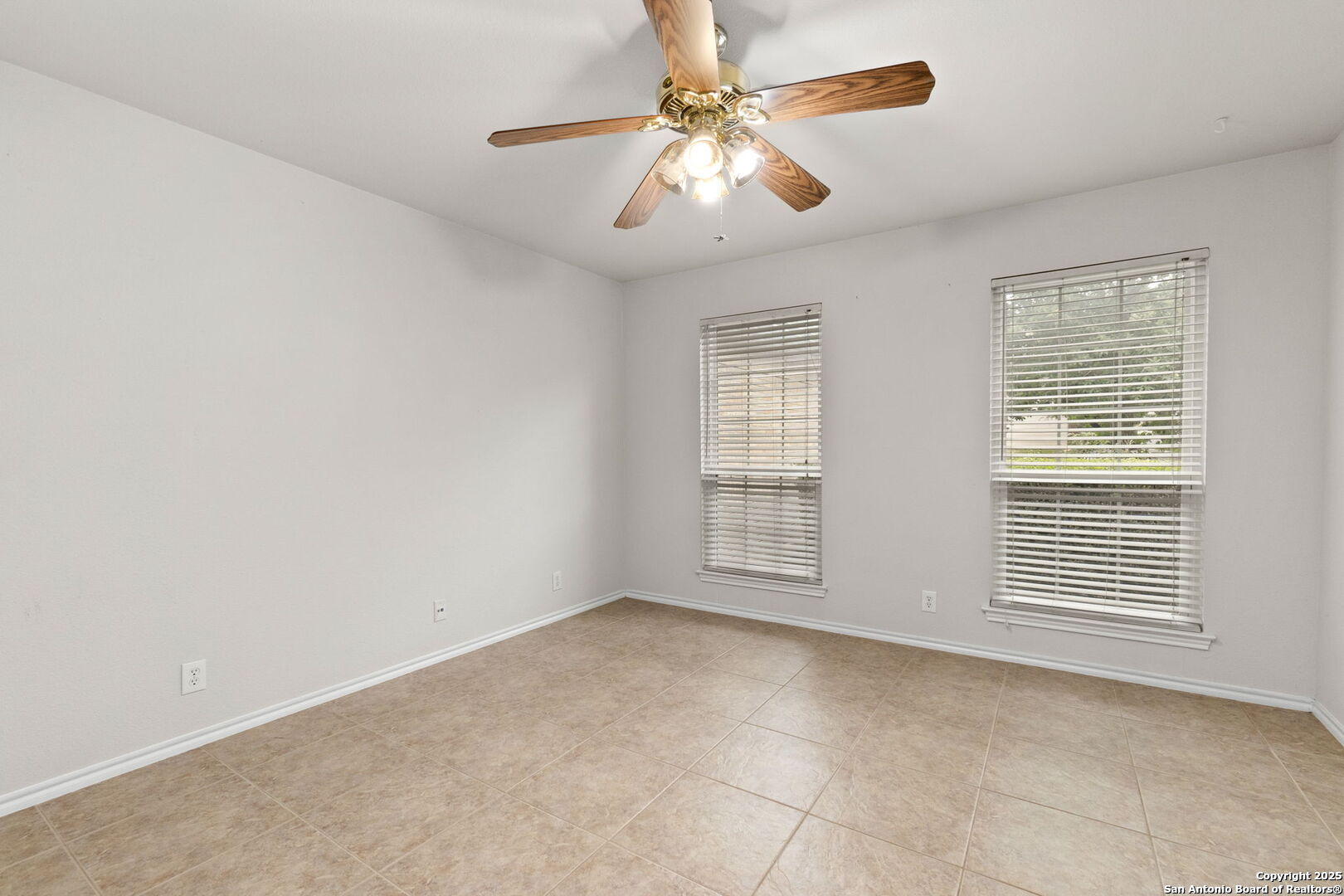15311 Spring Rock San Antonio, TX 78247 - Photo 27 of 32 an empty room with chandelier fan and windows