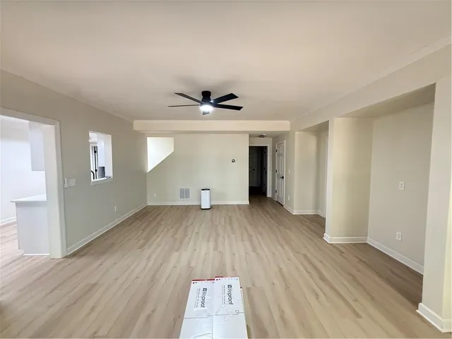 a living room with a bed and a ceiling fan