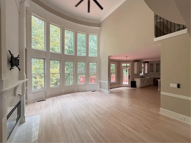 a view of an empty room with a window and wooden floor