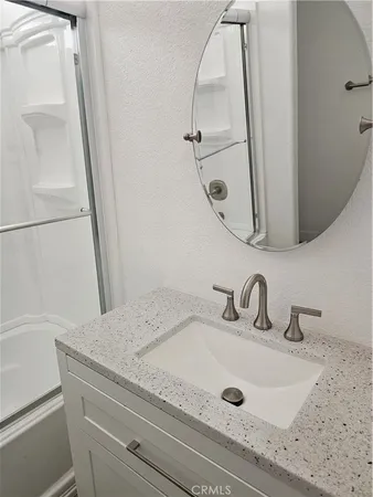 a bathroom with a granite countertop shower a toilet and a sink