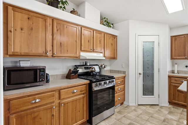 1637 East Midvalley Road Enoch, UT 84721 - Photo 13 of 48 Kitchen featuring stainless steel appliances, light countertops, and wood finish cabinetry