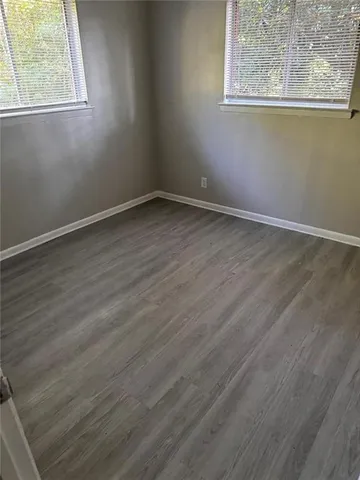 a view of a room that has wooden floor and windows in it