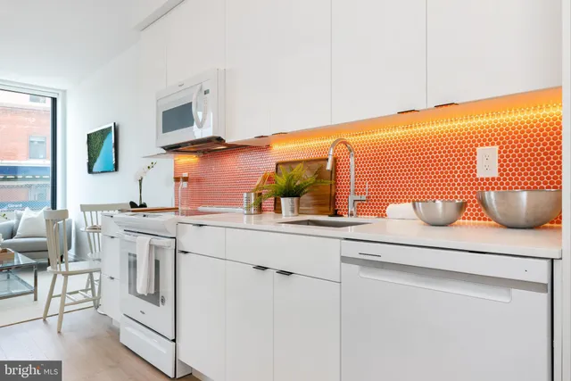 a kitchen with white cabinets and sink