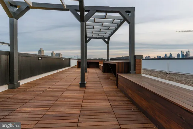 a roof deck with a dining table and chairs next to a yard