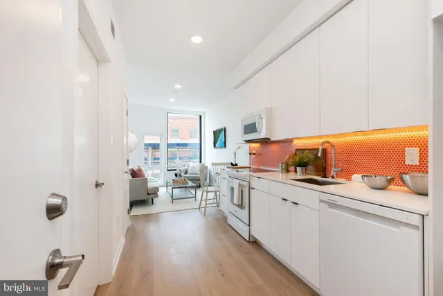 a kitchen with stainless steel appliances lots of counter top space and furniture