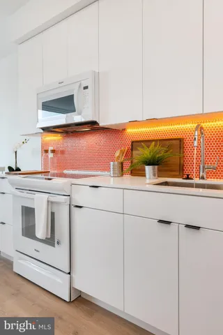 a kitchen with a stove and white cabinets