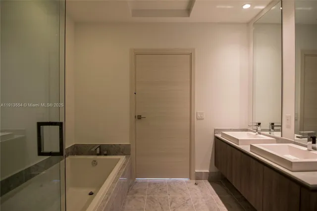 a bathroom with a tub sink and mirror