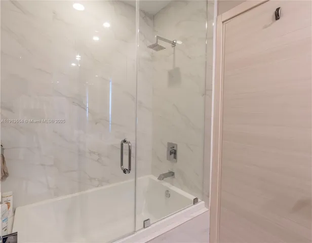 a white bath tub sitting next to a white sink and vanity