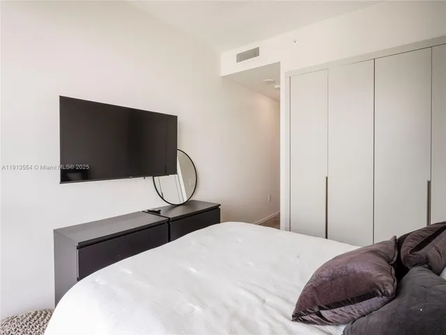 a bedroom with a bed and a flat screen tv