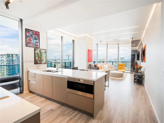 a large white kitchen with a large window and furniture