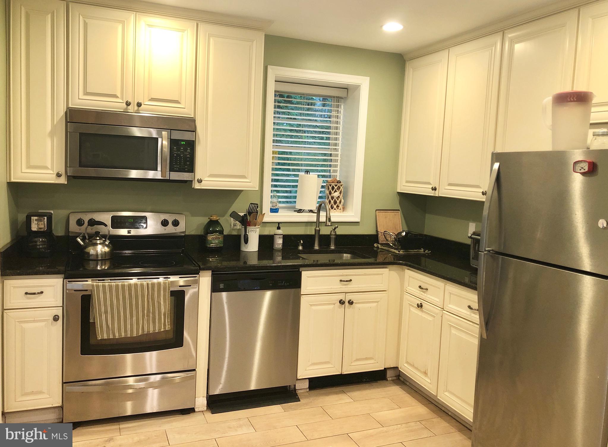 332 Arbutus Drive Edgewater, MD 21037 - Photo 2 of 31 a kitchen with granite countertop a refrigerator a sink a stove a microwave and cabinets