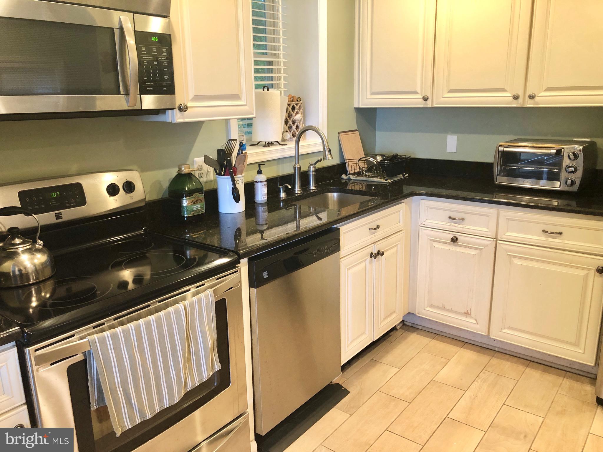 332 Arbutus Drive Edgewater, MD 21037 - Photo 4 of 31 a kitchen with granite countertop white cabinets and white appliances