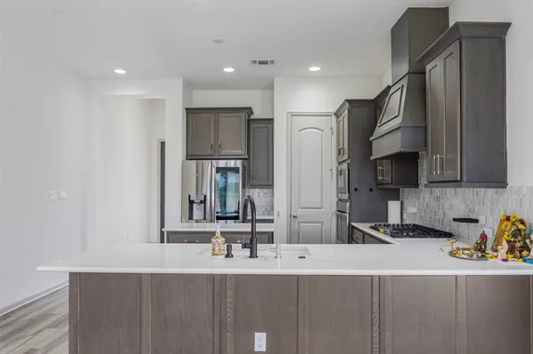 a kitchen with stainless steel appliances a sink stove and cabinets