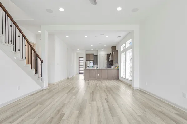 a view of a hallway with wooden floor and kitchen