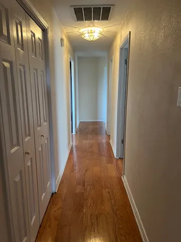 a view of a hallway with a wooden door