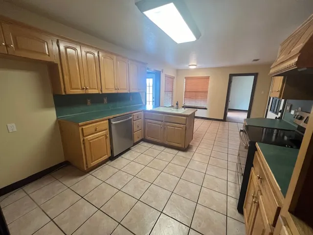 a kitchen with stainless steel appliances a sink a stove top oven a counter space and cabinets