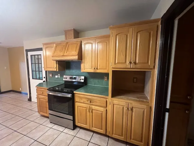 a kitchen with granite countertop a stove top oven cabinetry and a sink