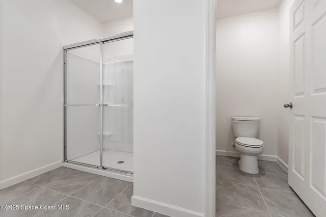 a bathroom with a granite countertop toilet and a shower