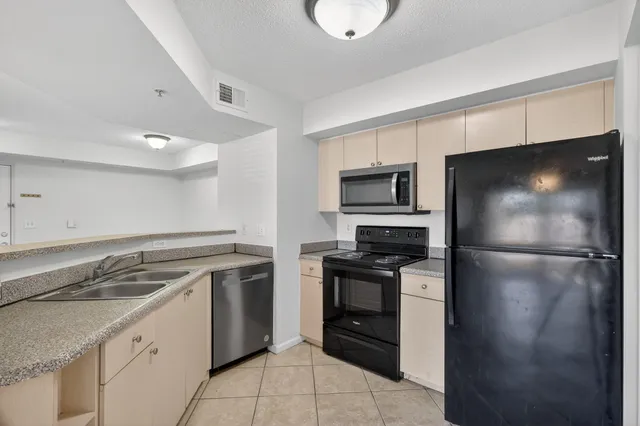 a kitchen with kitchen island a sink a wooden floor and a large window